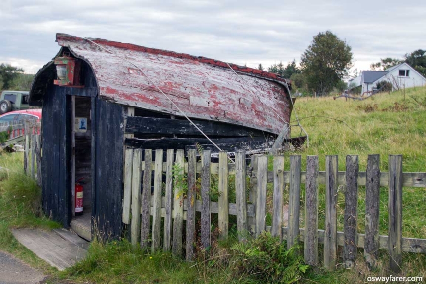 The novel unmanned ticket office at the Colbost Croft/Folk museum. An upturned wooden boat acts as the roof. Isle of Skye, Colbost Croft Museum - Ticket Office