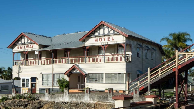 Built 1915; Two storey timber building - chamfer board facing; hipped roof with corrugated iron sheeting; Verandahs - 1st-floor gable-ended bays, timber posts and timber decorated balustrades, ground floor enclosed; 1 Station Road; Qld register #602540, 12 June 2008. Queensland Pubs